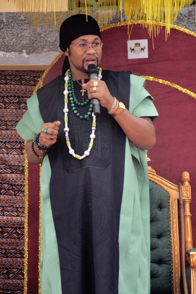 Sa Majesté Masambukidi Ier face à l'assemblée, microphone en main — discours d'anniversaire