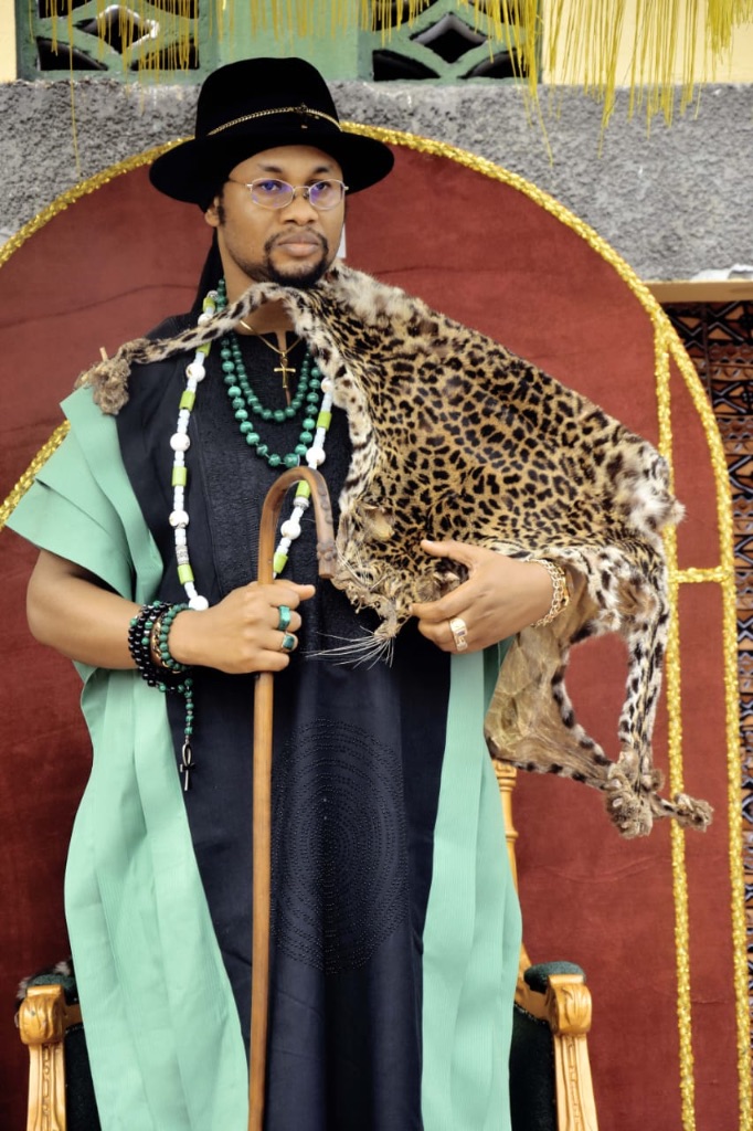 Sa Majesté Masambukidi Ier en tenue royale noire et verte, tenant le sceptre — cérémonie d'anniversaire