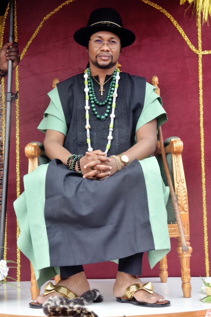 Sa Majesté Masambukidi Ier assis sur le trône royal, mains jointes — solennité royale